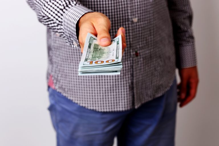 Closeup portrait of a male hand holding US dollars