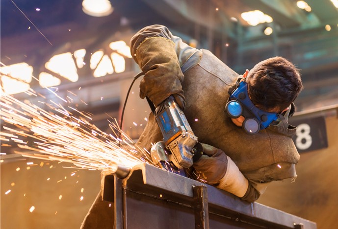 young man welding in factory